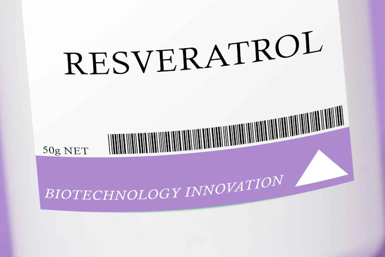 Close-up of label on a pack of resveratrol supplements. On a purple background.