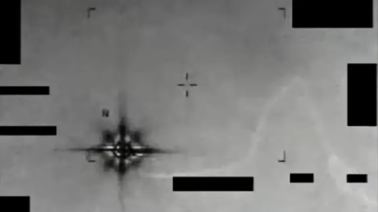 A grainy photo of a dark, blurry object in the sky.