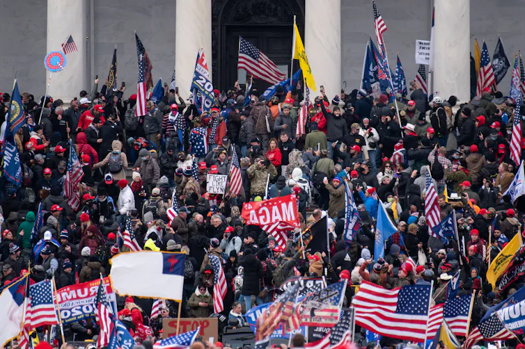 Rioters taking over the steps of a large, columned building.
