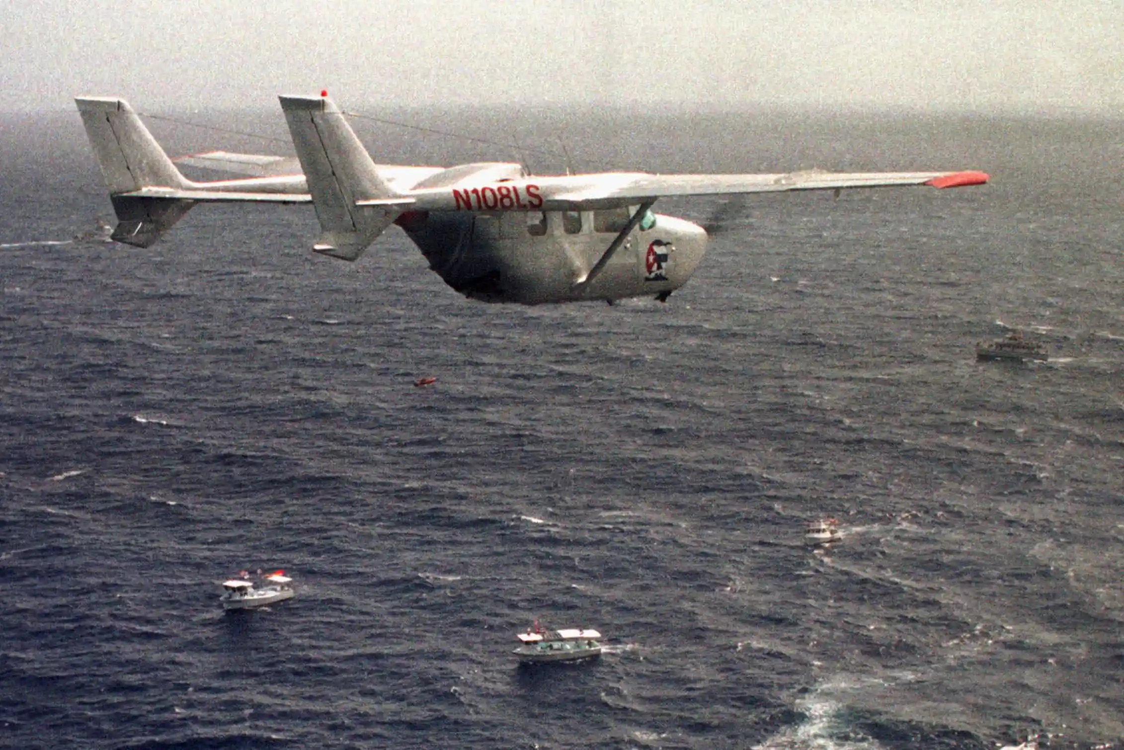 A military plane flies over the ocean