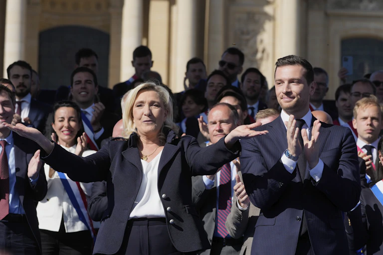 French far-right leader Marine Le Pen, left, reacts with Jordan Bardella during the French far-right party national rally near the parliament in Paris, Sunday, April 6, 2025