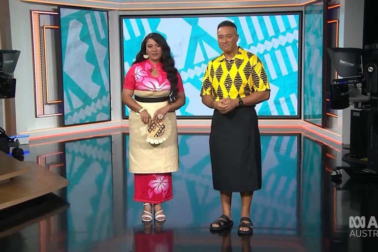 Two Pacific Islander news presenters in a television studio