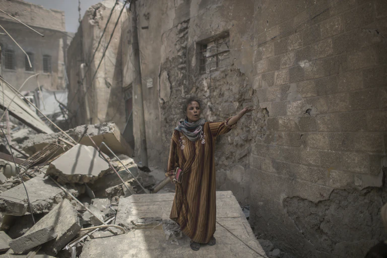 A civilian flees through a destroyed alley in Mosul