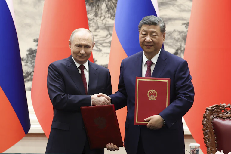 Vladimir Putin shakes hands with Xi Jinping, Beijin, May 2026.
