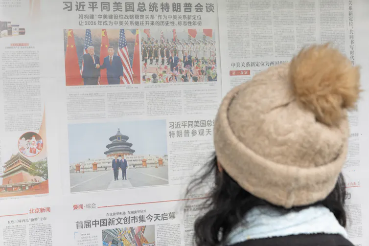 A young Chinese woman reads reports of Donald Trump's visit to Beijing.