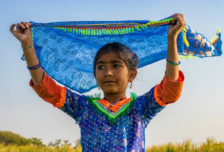 Disminución de la participación electoral en Pakistán: por qué se registrarán más mujeres, pero menos votantes en 2024 1 Una chica con un vestido colorido sostiene un pañuelo sobre su cabeza ondeando al viento.