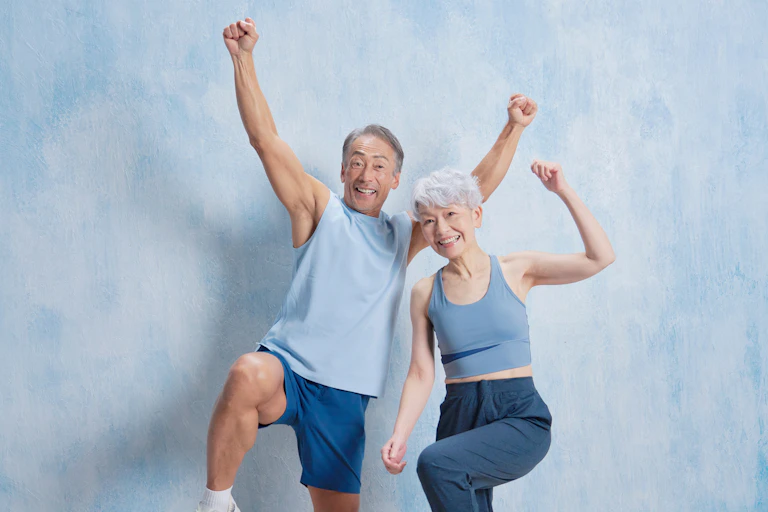 Older man and woman looking happy and active in sportswear