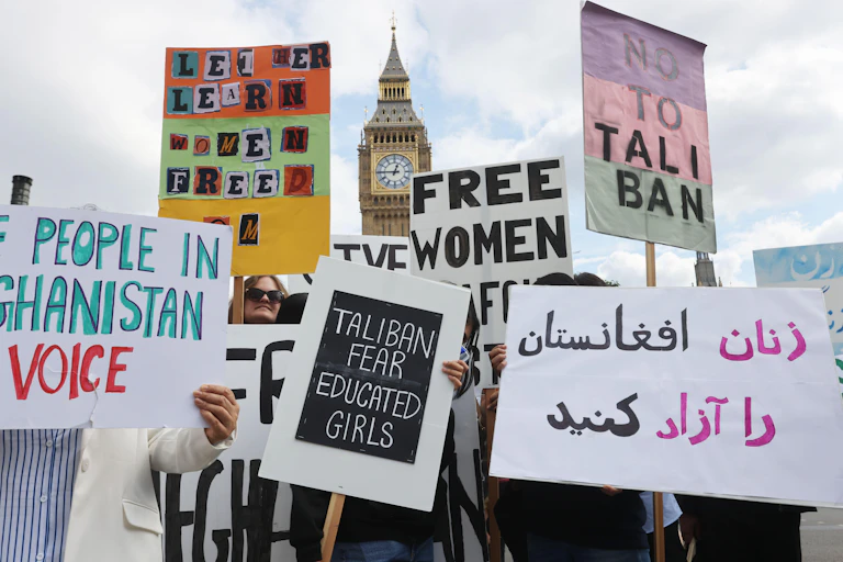 People holding placards. One reads 'Taliban fear educated girls'