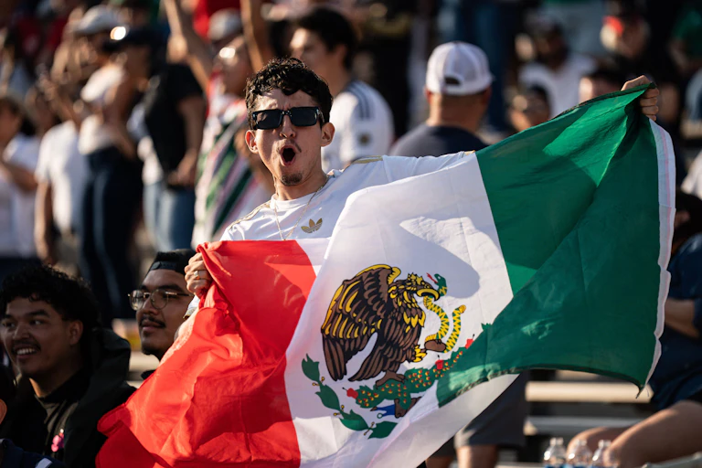 A Mexico fan holding a Mexican flag.