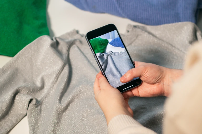 A person taking a camera shot of their clothes.
