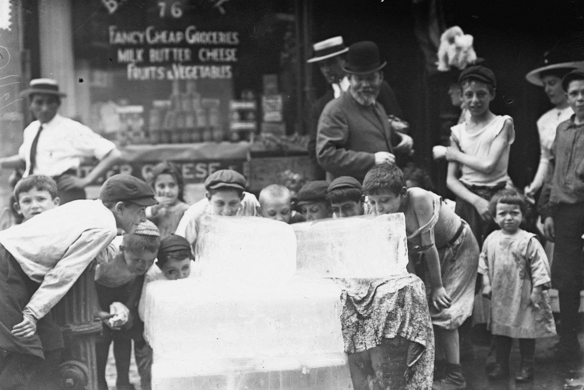 Children cool down with a giant block of ice in New York