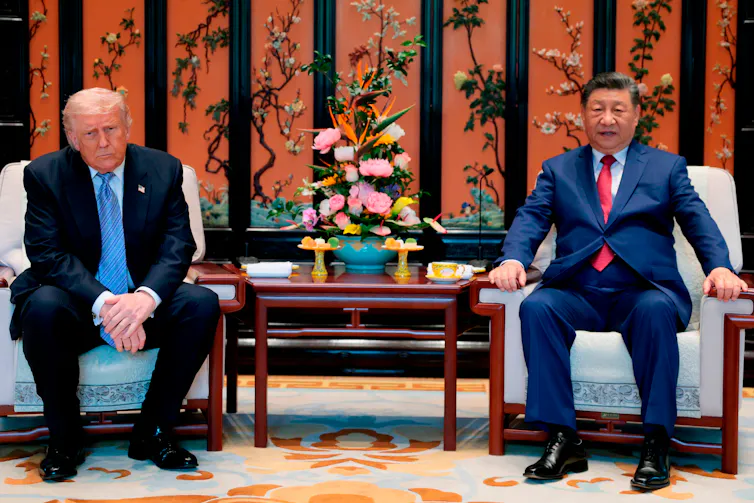 Trump et Xi Jinping sont assis sur des fauteuils, un bouquet de fleurs à leur côté