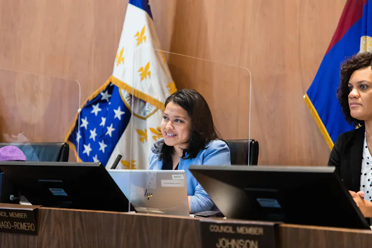 Woman sits behind a computer.