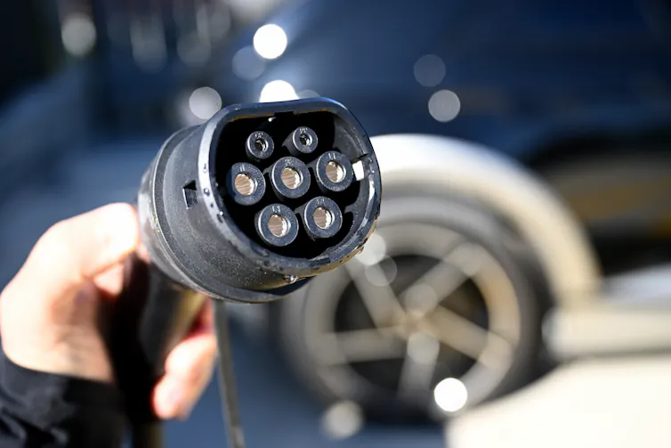 A hand holding an EV vehicle charging plug.