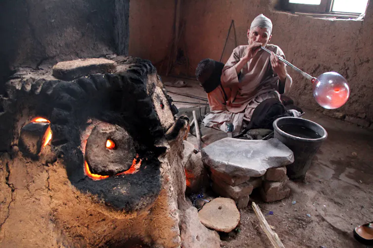An Afghan glass blower works at a local glass factory in Herat, Afghanistan.