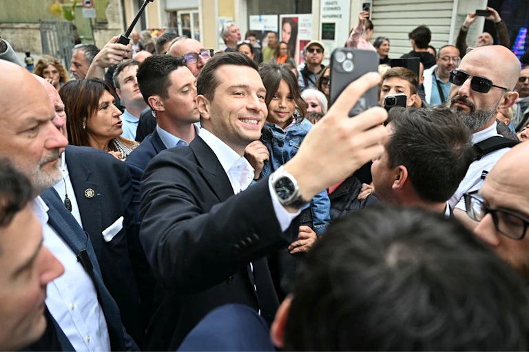 Jordan Bardella prenant des elfies avec des admirateurs venus à sa rencontre.