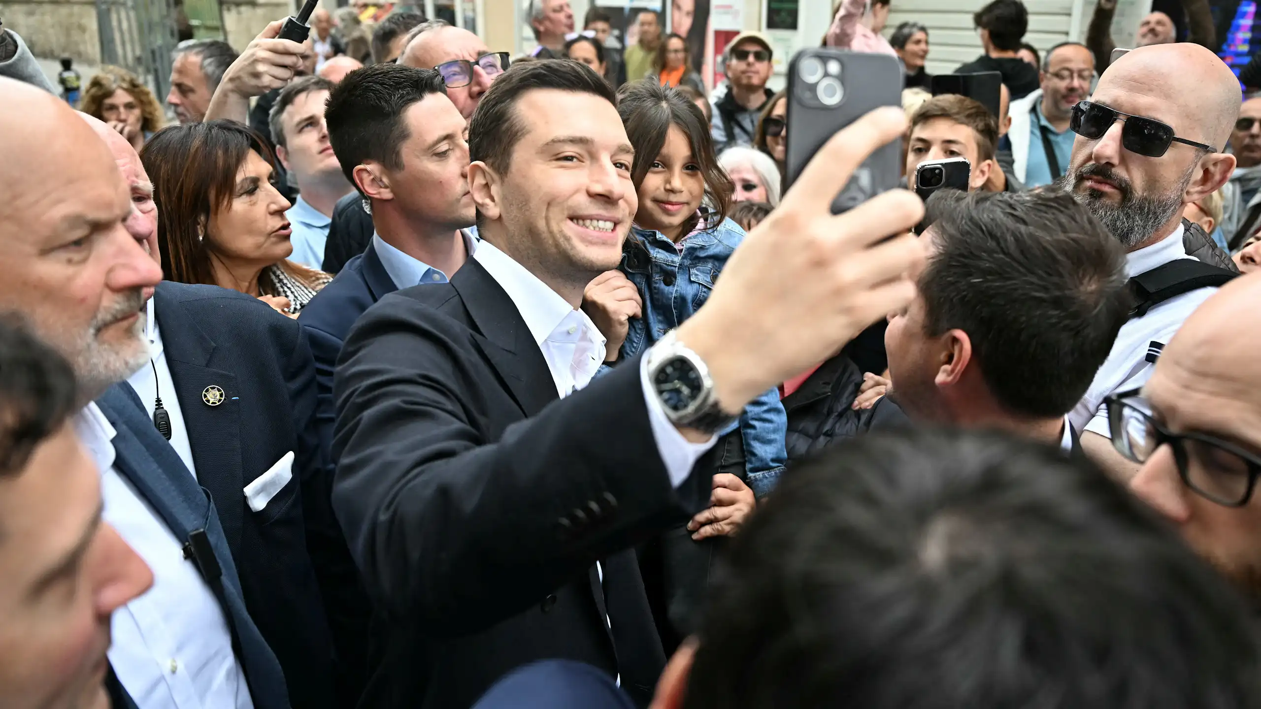 Jordan Bardella prenant des elfies avec des admirateurs venus à sa rencontre.