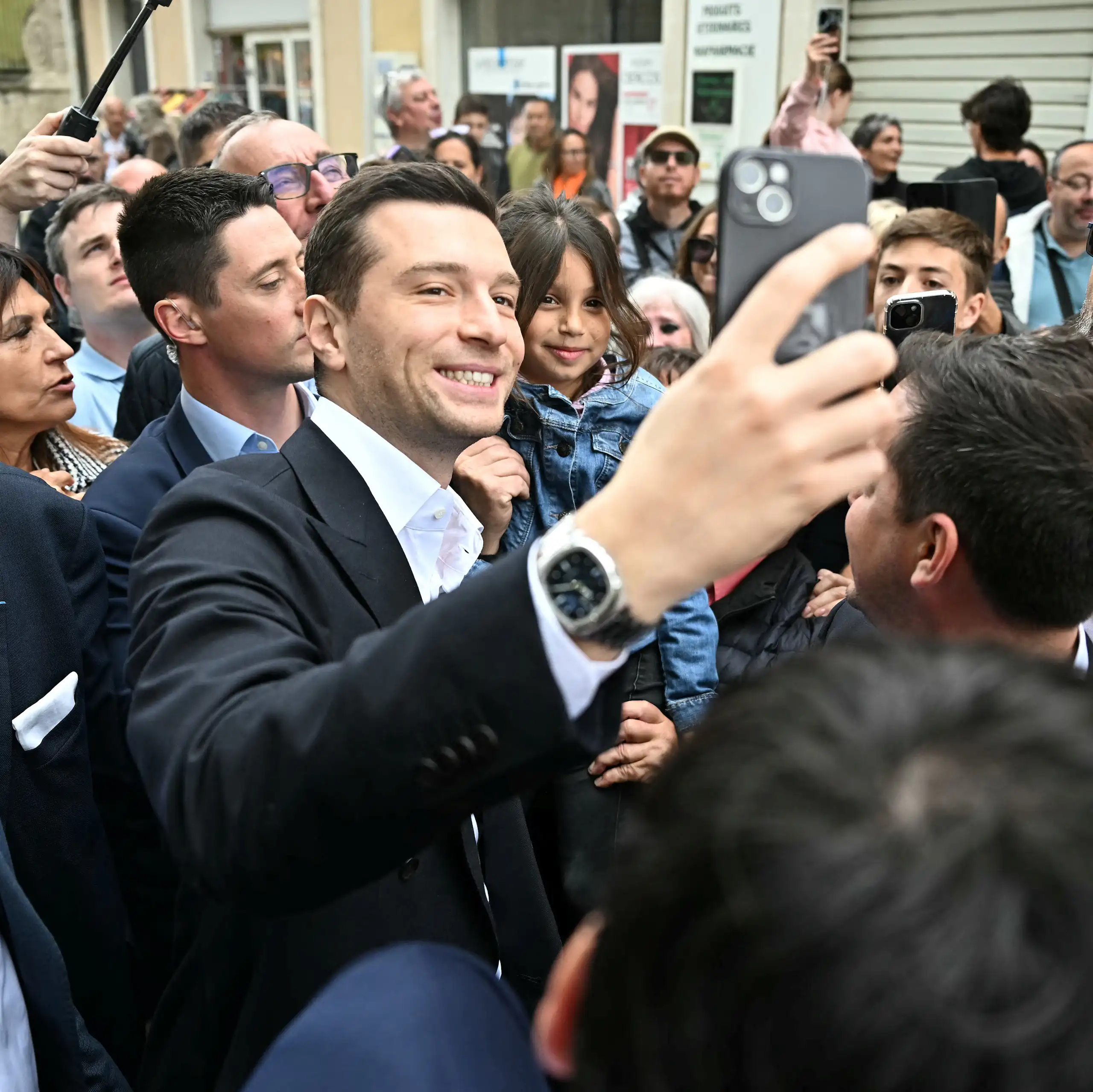 Jordan Bardella prenant des elfies avec des admirateurs venus à sa rencontre.