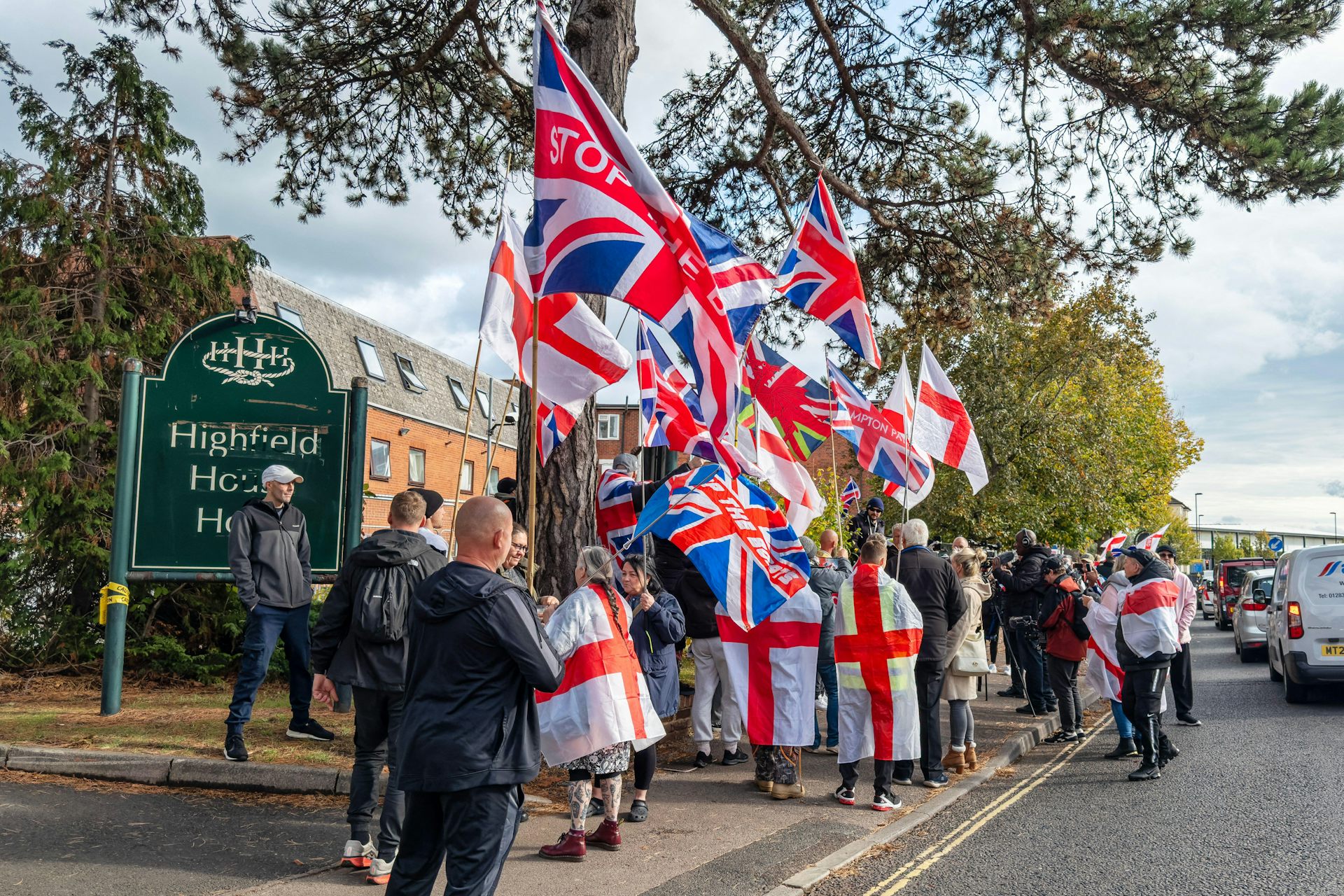 Protesters draped in UK and St George's flags outside a hotel housing asylum seekers