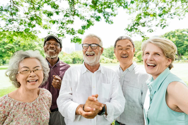 Five older adults smiling in an outdoor setting