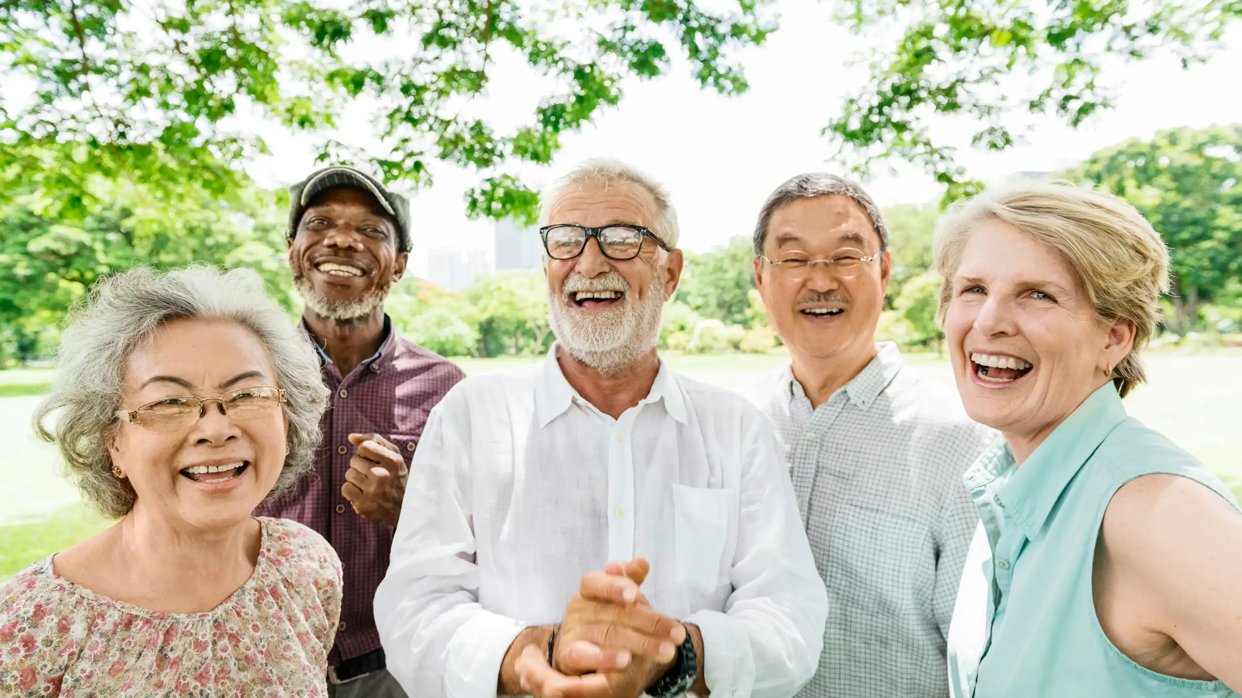 Five older adults smiling in an outdoor setting