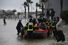 Officials rescue people in an inflatable boat