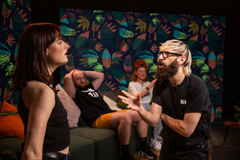 Two comedians performing an improvised scene on stage.