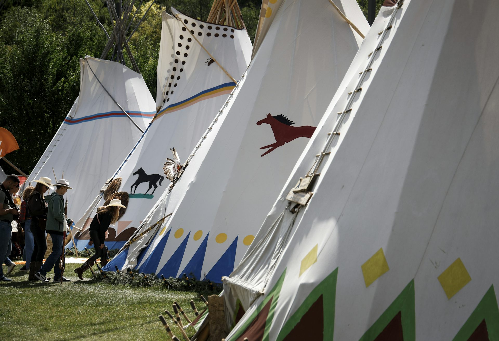 En el tipi entran personas con sombreros de vaquero.
