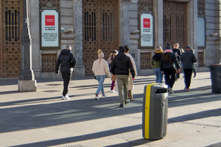 Personas caminando en un día soleado cerca del Ministerio de Medio Ambiente, Agricultura e Interior de Madrid, España