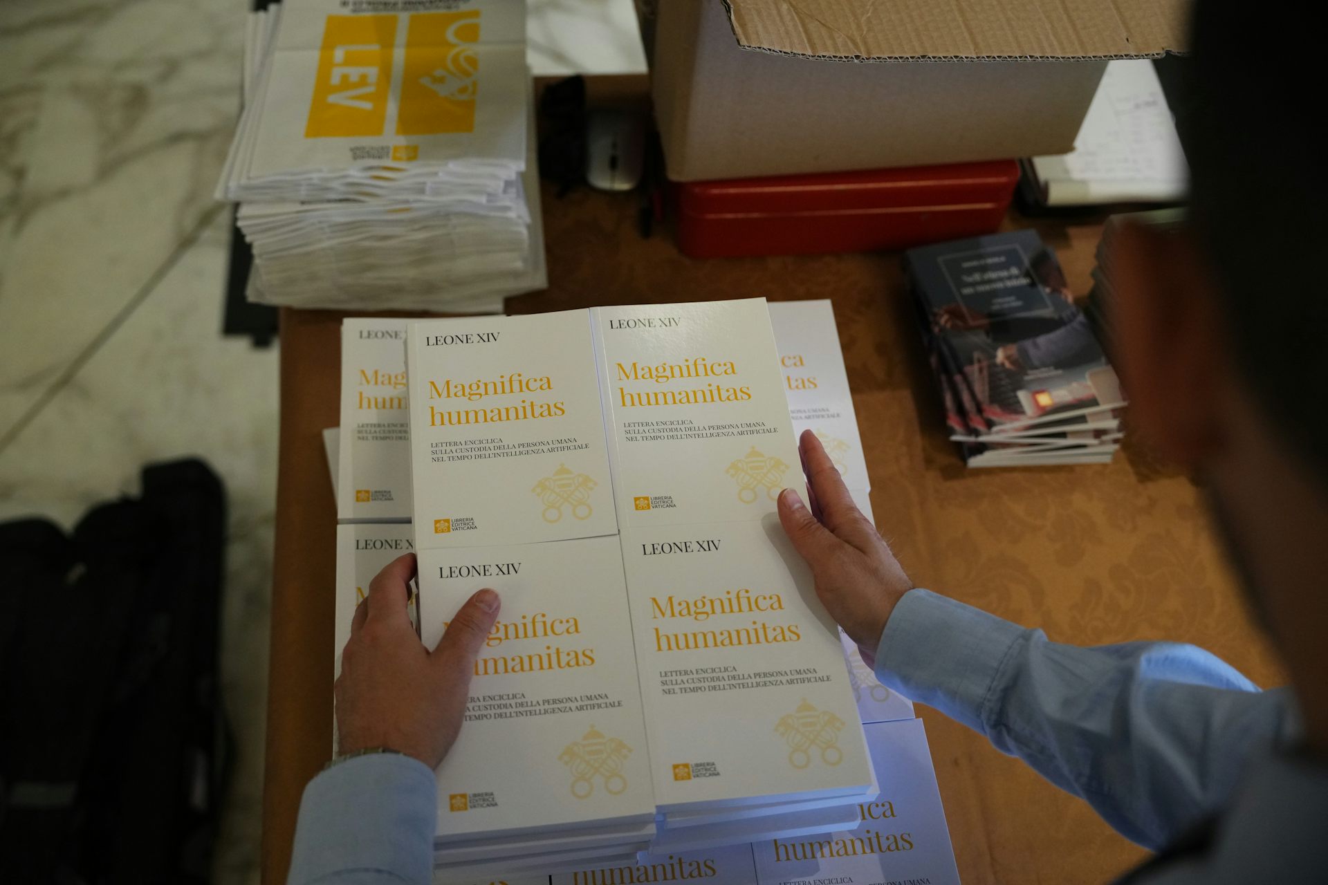 Una persona sostiene copias de un documento llamado Magnifica Humanitas.