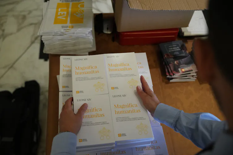 El Papa León XIV compara la inteligencia artificial con la revolución industrial: cómo se están formando nuevas alternativas a las grandes empresas de IA 1 Una persona sostiene copias de un documento llamado Magnifica Humanitas.