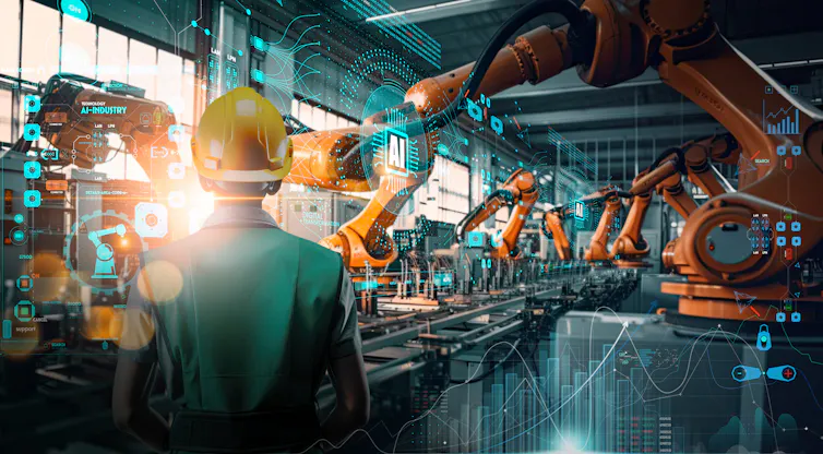 El Papa León XIV compara la inteligencia artificial con la revolución industrial: cómo se están formando nuevas alternativas a las grandes empresas de IA 2 Un trabajador se encuentra frente a brazos robóticos impulsados por inteligencia artificial en una fábrica automatizada.