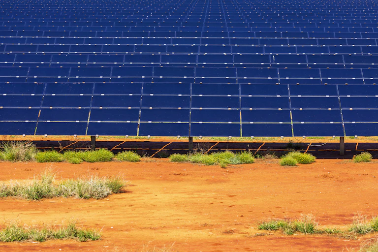 blue solar panels against red dirt, close up of solar farm