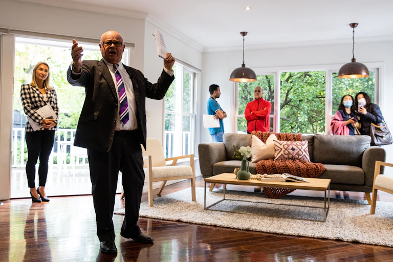 An auction director conducts an auction inside a property