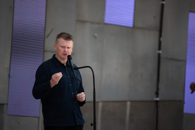 A man standing at a microphone and speaking