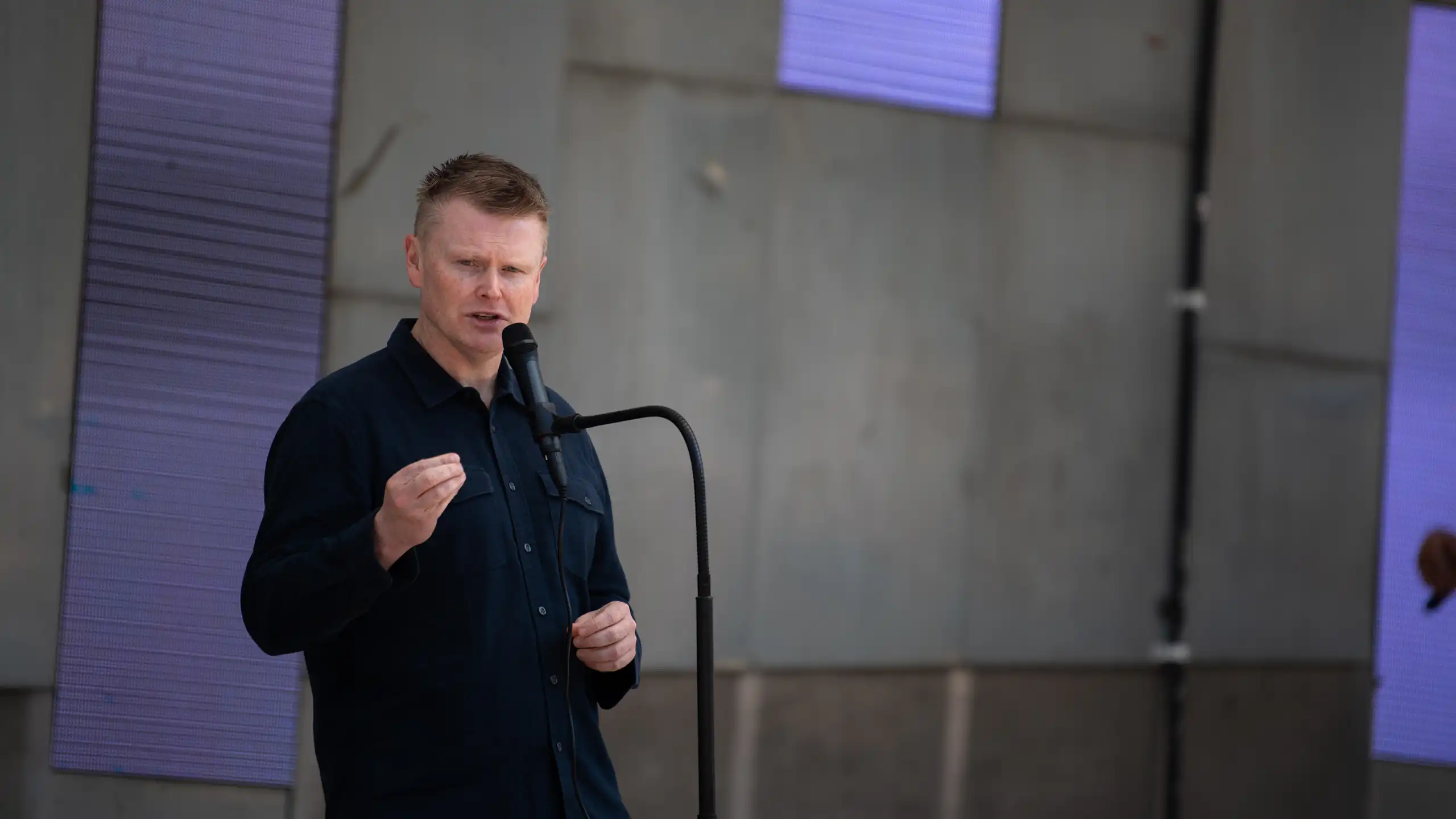 A man standing at a microphone and speaking