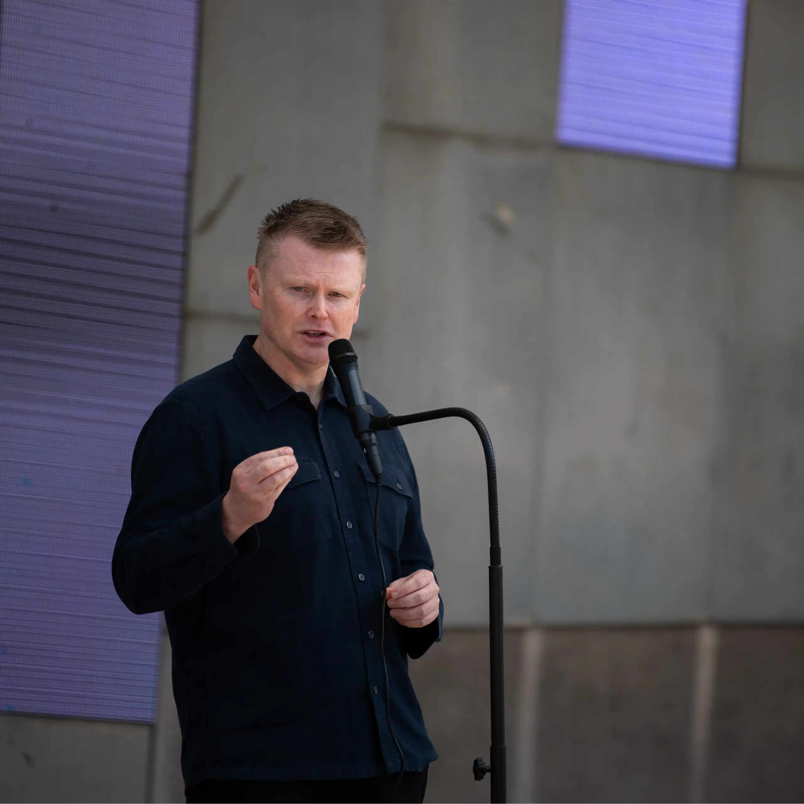 A man standing at a microphone and speaking