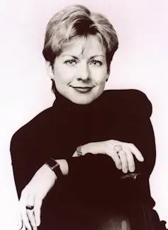 a smiling blonde woman in black