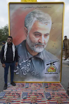 El estrecho de Ormuz: el bucle de la cadena de suministro que rompió el mundo 3 Los dolientes caminan sobre banderas estadounidenses con fotografías del presidente estadounidense Donald Trump debajo de una fotografía de Qassem Soleimani.