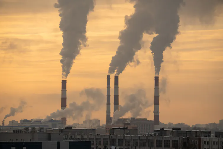 Smokestacks from a coal plant against hazy sky.
