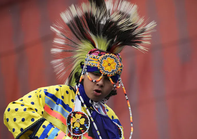 Bailarina nativa con atuendo ceremonial, incluida una diadema de cuentas.