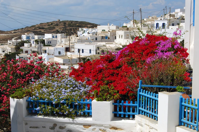 A Greek village on a hilliside, with many homes painted white.