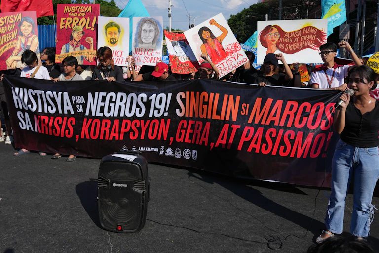A group of people hold a large banner.
