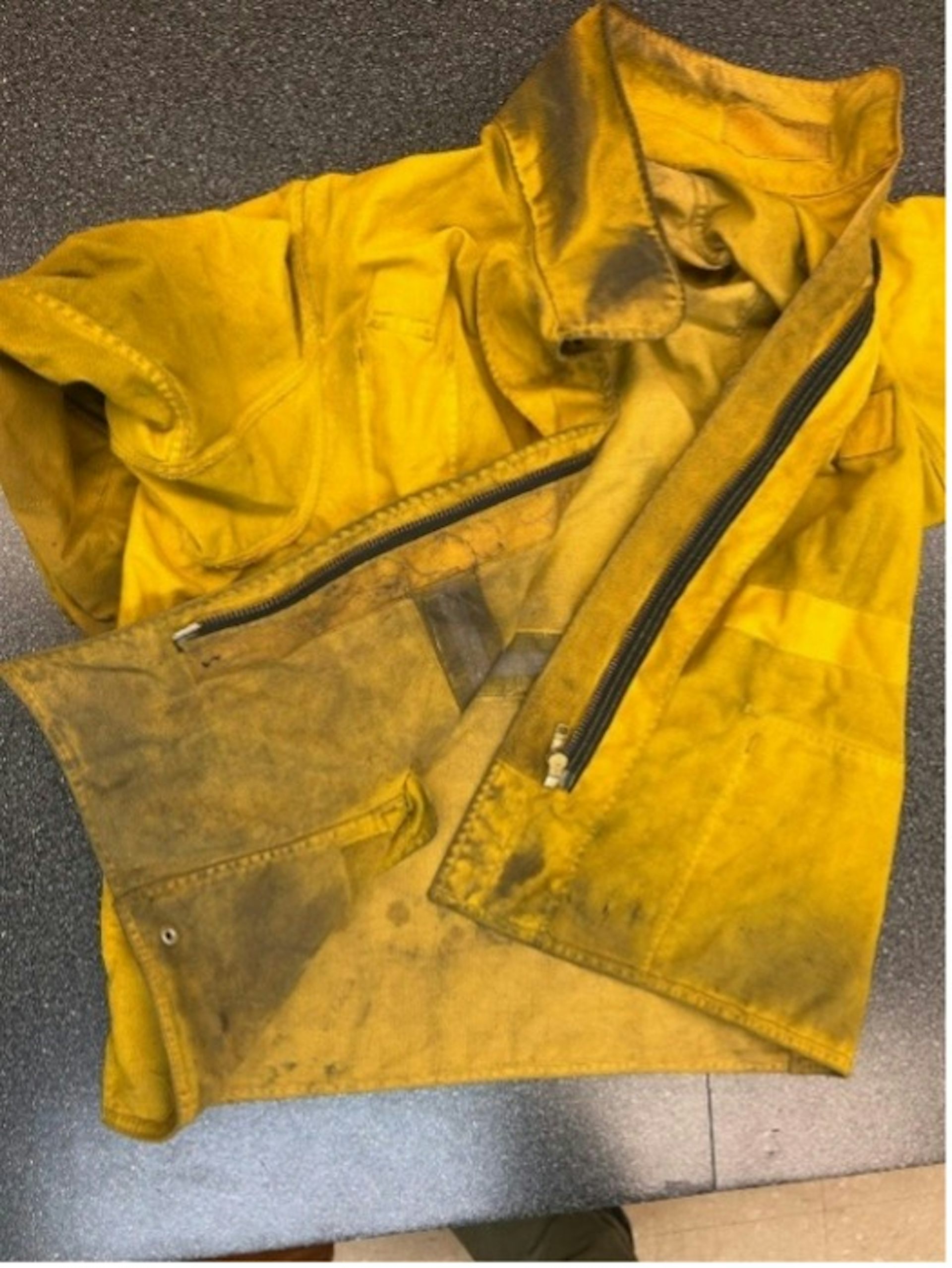 Una chaqueta de bombero amarilla con hollín.