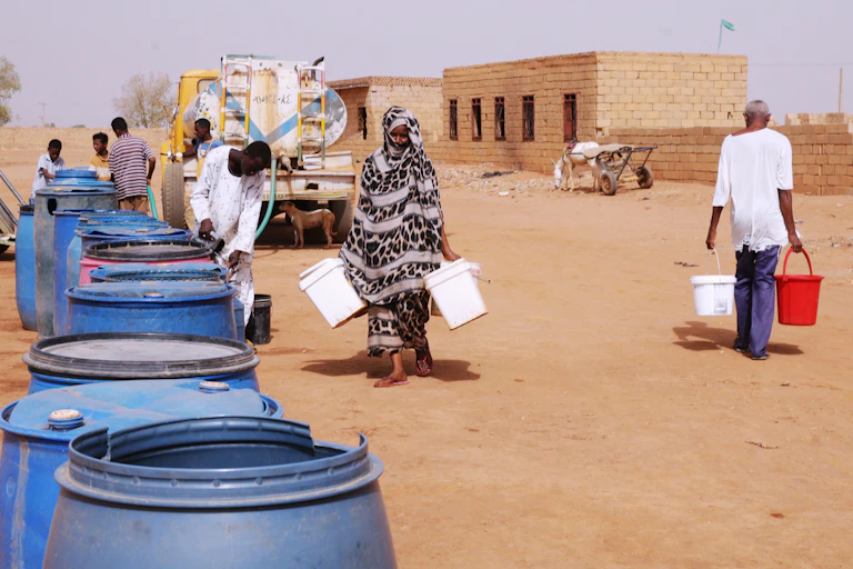 People fill water containers at a free distribution point amid water outages in Khartoum, Sudan