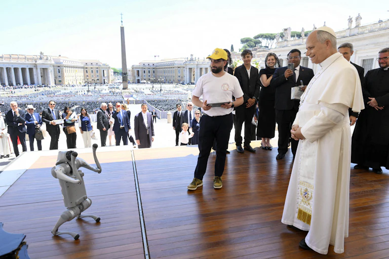 Pope Leo XIV meets a small humanoid robot in Saint Peter's Square, Vatican City,