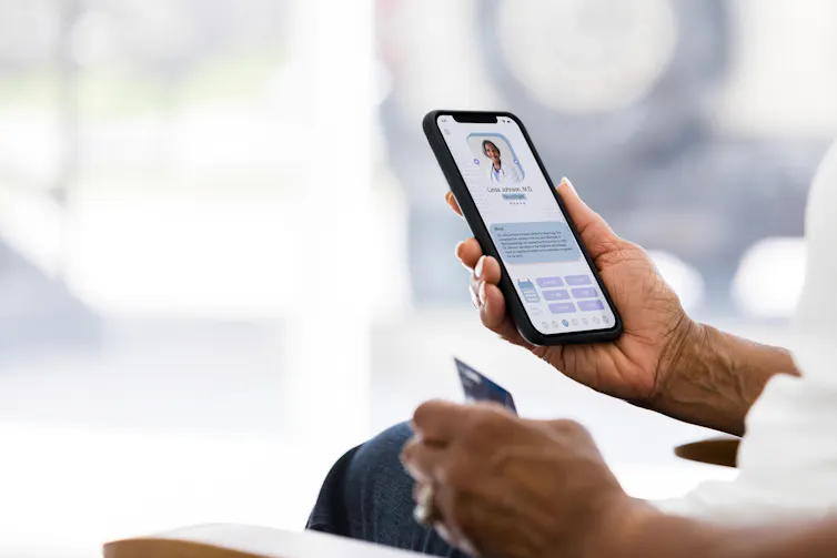 A person holds a phone screen that shows a text bubble and an image of a person in a white lab coat.