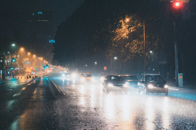 A city street at night in heavy rain.