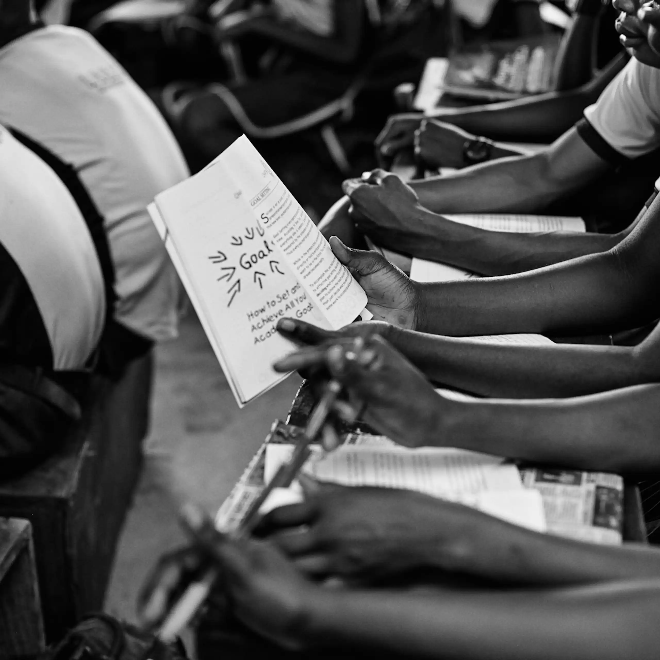 Black and white photo of young people sitting in rows