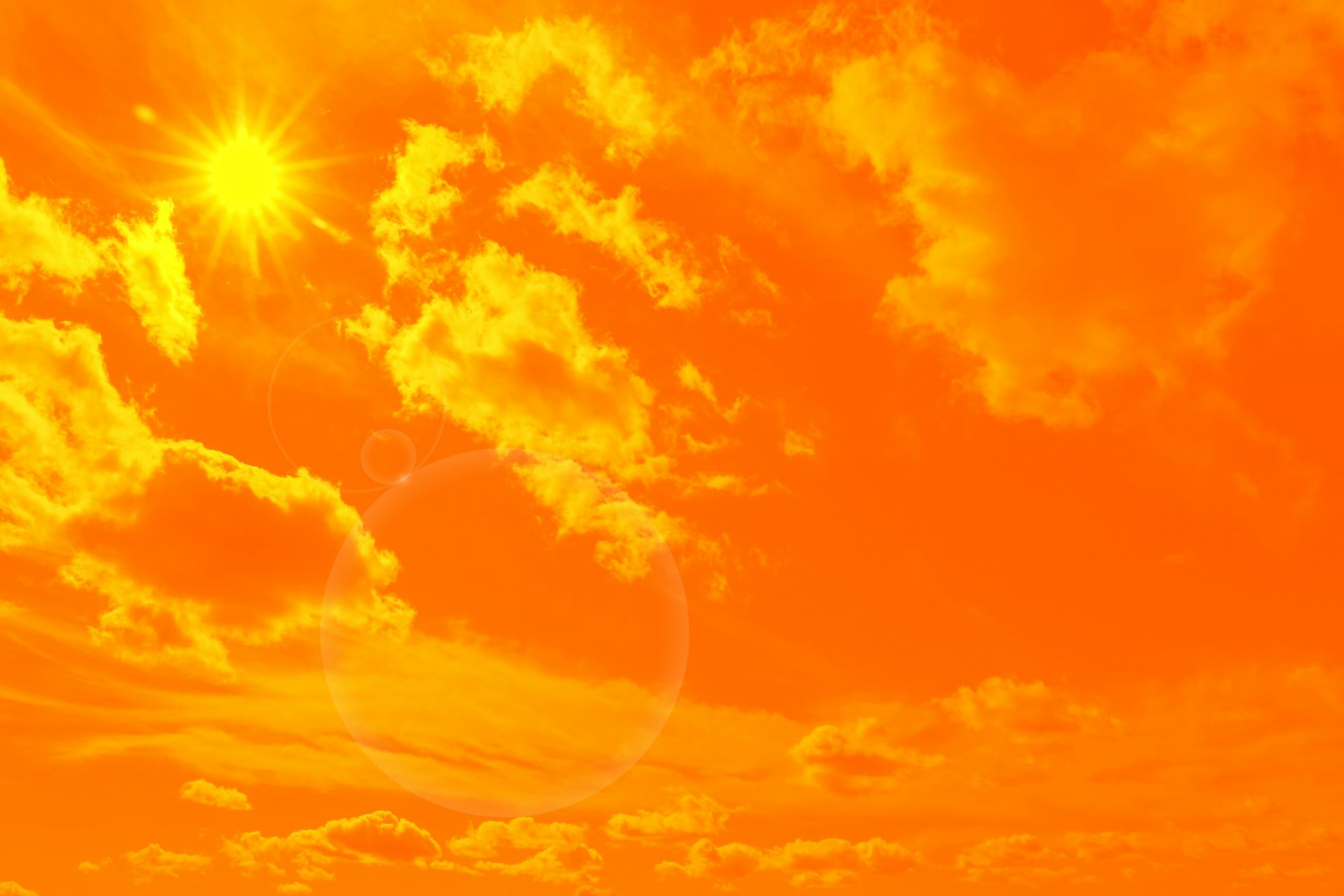Un sol molt fort pinta el cel de taronja.